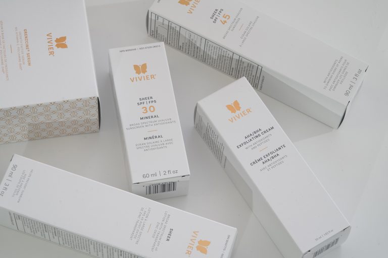 Photo showing various packages of Vivier brand skin care products, including sunscreens and exfoliating creams, arranged on a white surface.