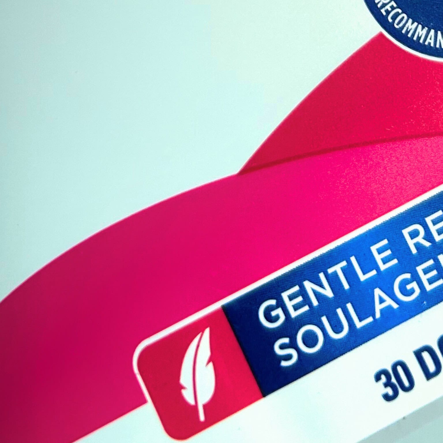 Gros plan sur un emballage de produit montrant un design en relief doux avec les mots 'Gentle Relief' et 'Soulagement Doux' en anglais et en français.