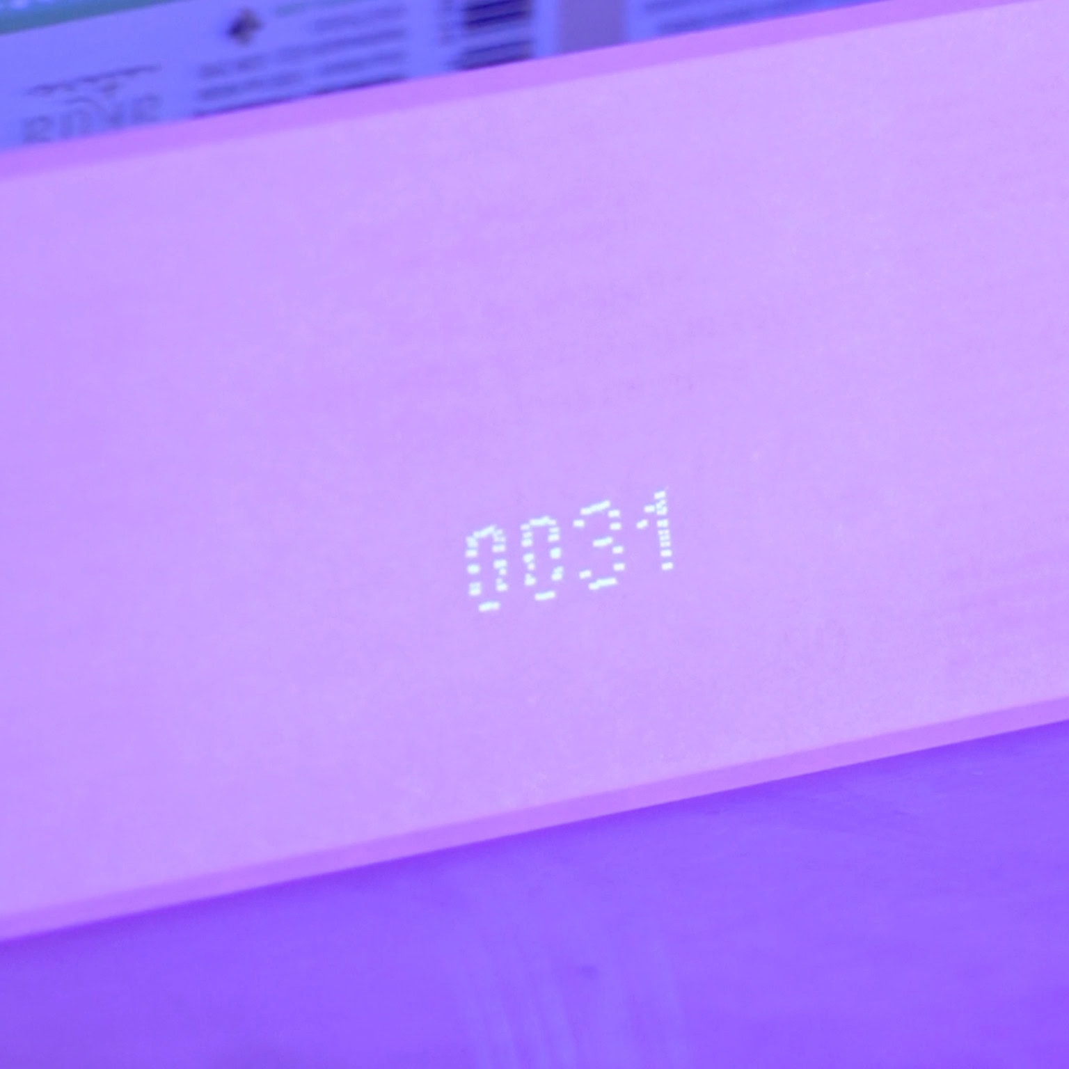 Image montrant un étiquetage UV sur un emballage, visible sous une lumière ultraviolette avec le code '0031'.