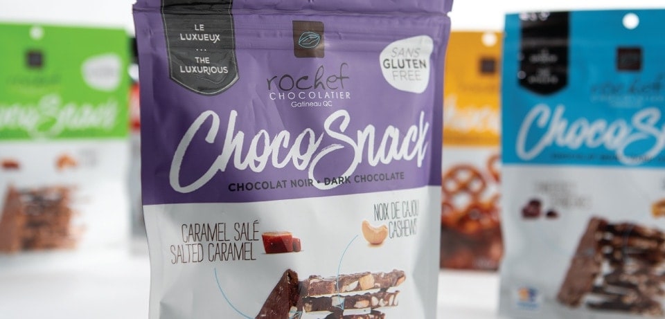 Emballages de ChocoSnack sans gluten Image d'un assortiment d'emballages de ChocoSnack de Rochef Chocolatier, mettant en avant des saveurs telles que caramel salé et noix de cajou, avec l'étiquette sans gluten.