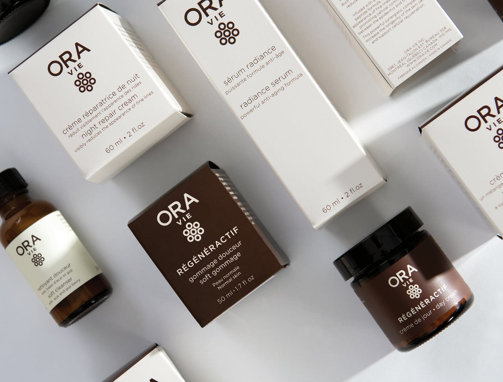 Collection de produits de soins de la peau ORA Vie Image de divers emballages de produits de soins de la peau de la marque ORA Vie, incluant des crèmes réparatrices, des sérums radiance et des gommages.