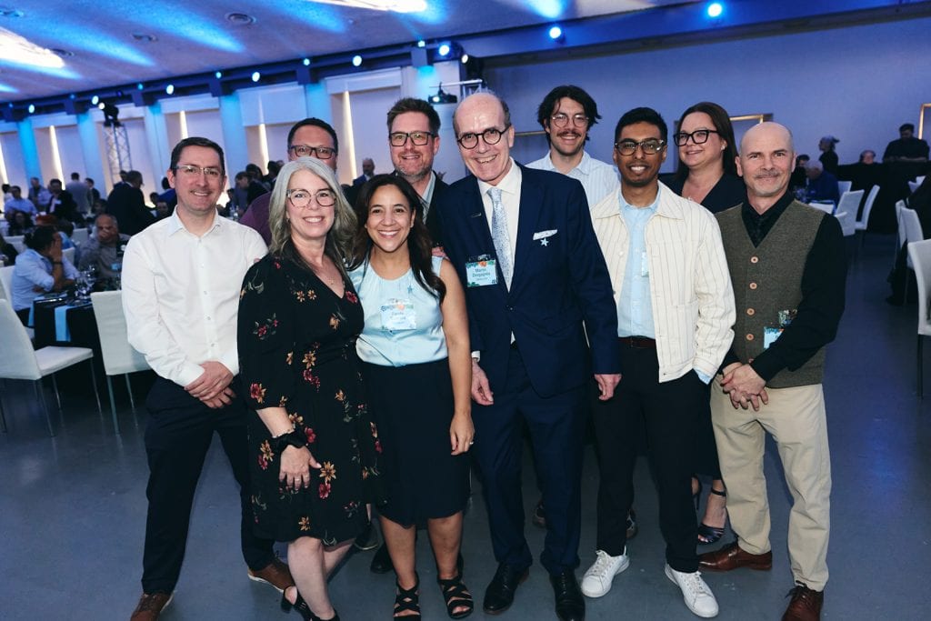 Groupe diversifié de professionnels souriants lors d'une conférence ou d'un séminaire d'affaires.
